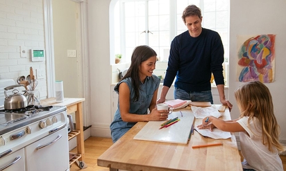 A family chatting together in the kitchen.