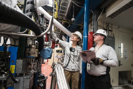 Factory workers assessing equipment