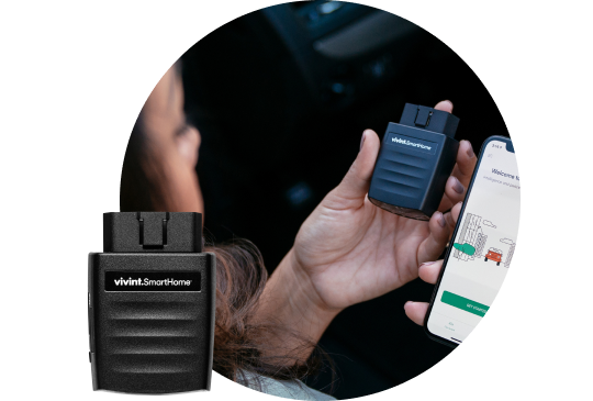 Image of a vivint car guard in the forefront, and a car parked in a driveway in the background
