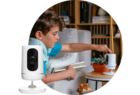 Boy touching the indoor camera on a side table