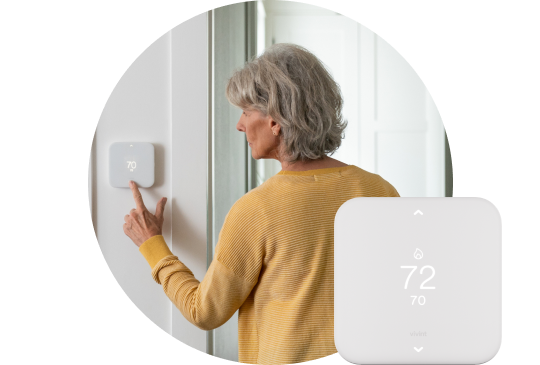 Woman using her Smart Thermostat to adjust the temperature