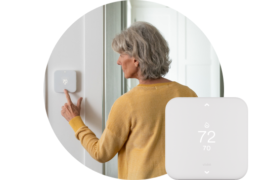 Woman using her Smart Thermostat to adjust the temperature