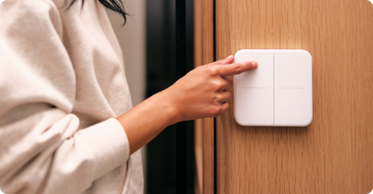 Women selects her Vivint Smart Light Switch to turn on her lights